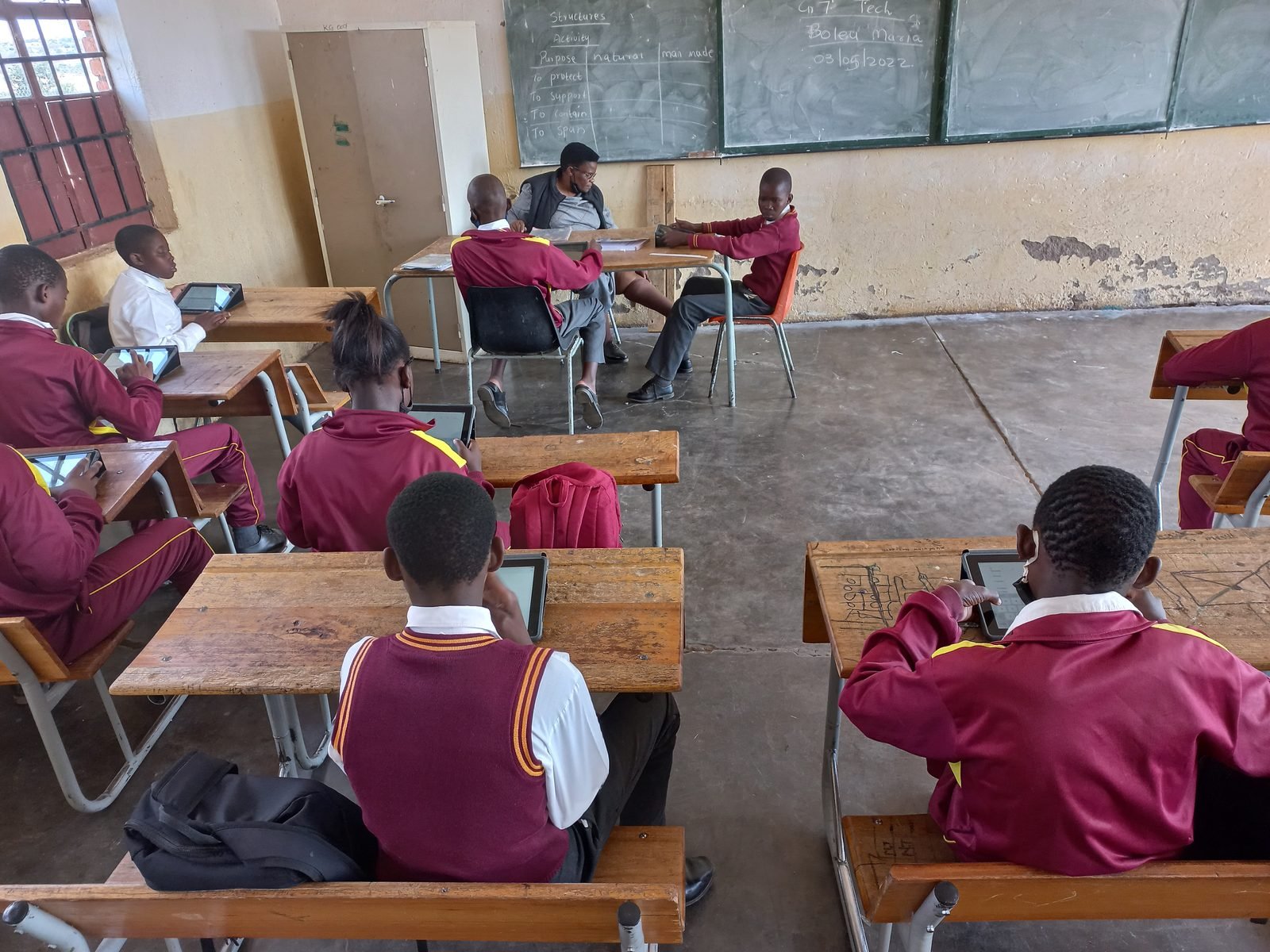 South African children using digital tablets in a classroom, learning with technology