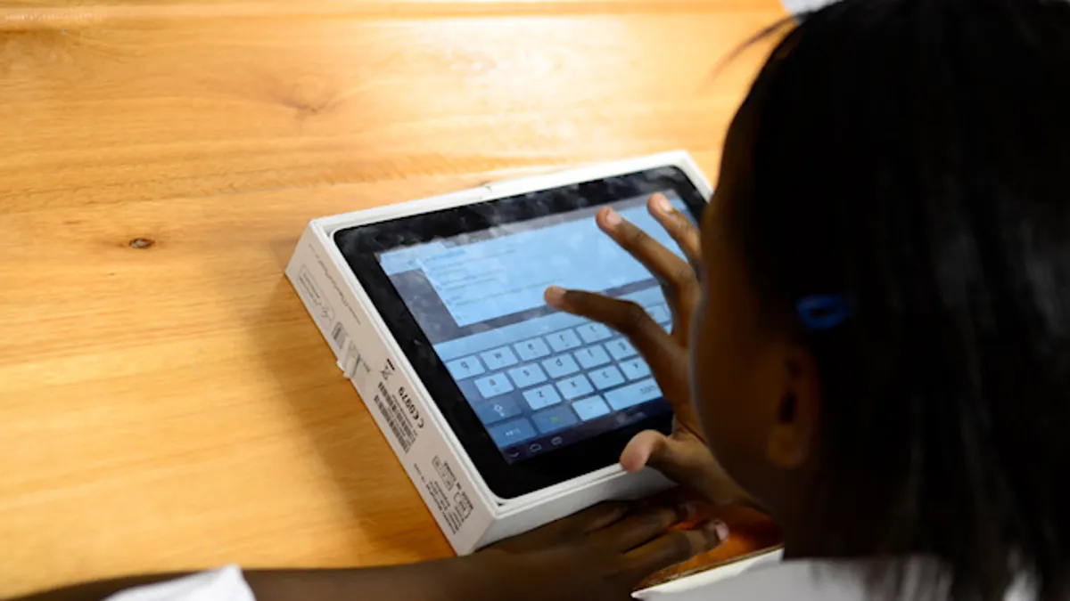 South African student using a tablet for learning in a classroom setting